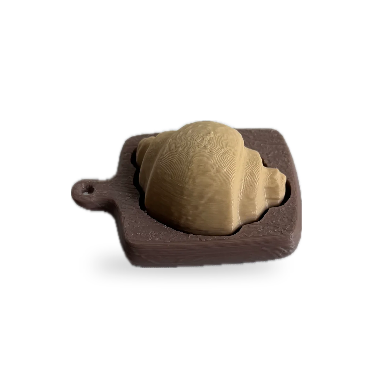 Golden croissant clicker on a brown cutting-board base